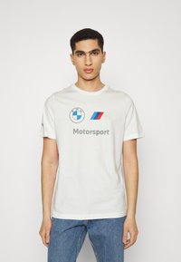 Hvid bomulds t-shirt med BMW og Motorsport logoer i sort, rød og blå. Rund halsudskæring, korte ærmer og en afslappet pasform.