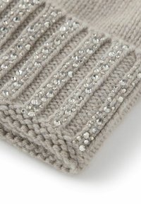 Dzianinowa szara tkanina o prążkowanej fakturze, ozdobiona przezroczystymi, fasetowanymi kryształkami ułożonymi w pionowe wzory dla dodatkowego efektu.
