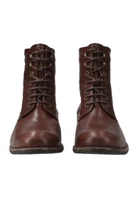 Bottines en cuir marron avec bouts ronds, lacets apparents et œillets en métal. Texture lisse avec une finition légèrement polie.
