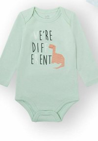 Body para bebé de manga larga en verde menta con cuello redondo, con un gráfico de dinosaurio y el texto "SOMOS DIFERENTES" en colores contrastantes.