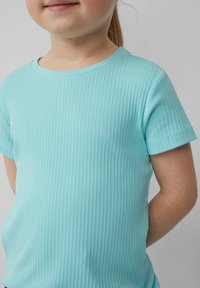 Licht turquoise geribbelde t-shirt met korte mouwen en een ronde halslijn, voorzien van een subtiele textuur. Het ontwerp benadrukt comfort en informele kleding.