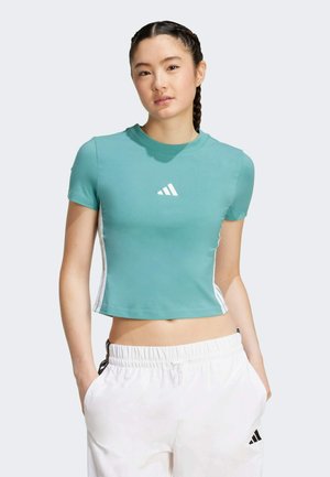 Top corto a maniche corte di colore teal realizzato in tessuto morbido, con un logo Adidas bianco sul petto e strisce laterali bianche a contrasto.