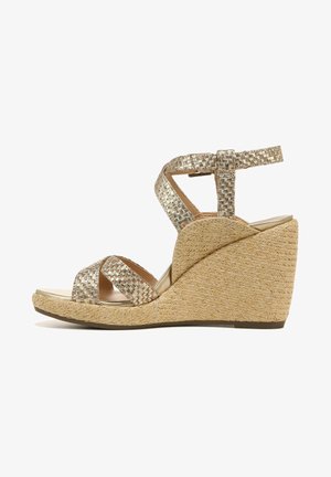 Wedge sandals with a woven gold and silver strap, open toe design, and a textured natural fiber wedge heel. Adjustable ankle strap included.