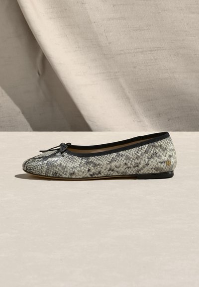 Ravna baletna cipela s crnim obrubom, malom mašnom na vrhu prsta i uzorkom svijetlosive kože zmije, prikazana s bočne strane na neutralnoj površini.
