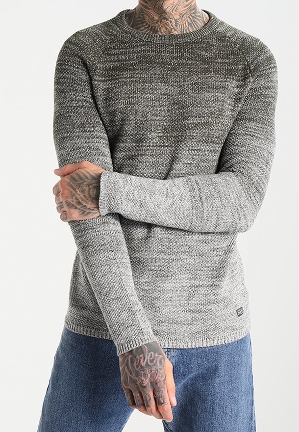 Grauer Strickpullover mit strukturiertem Muster, rundem Ausschnitt und langen Ärmeln, kombiniert mit blauer Jeans. Lässiges Design mit gerippten Bündchen.