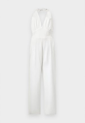 Combinaison blanche sans manches avec col halter, décolleté en V profond, taille cintrée et pantalons à jambes larges.