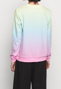 Ombre sweatshirt i mjukt tyg som övergår från ljusgrön till rosa. Har en rundad halsringning och ribbade ärmslut och nederkant.