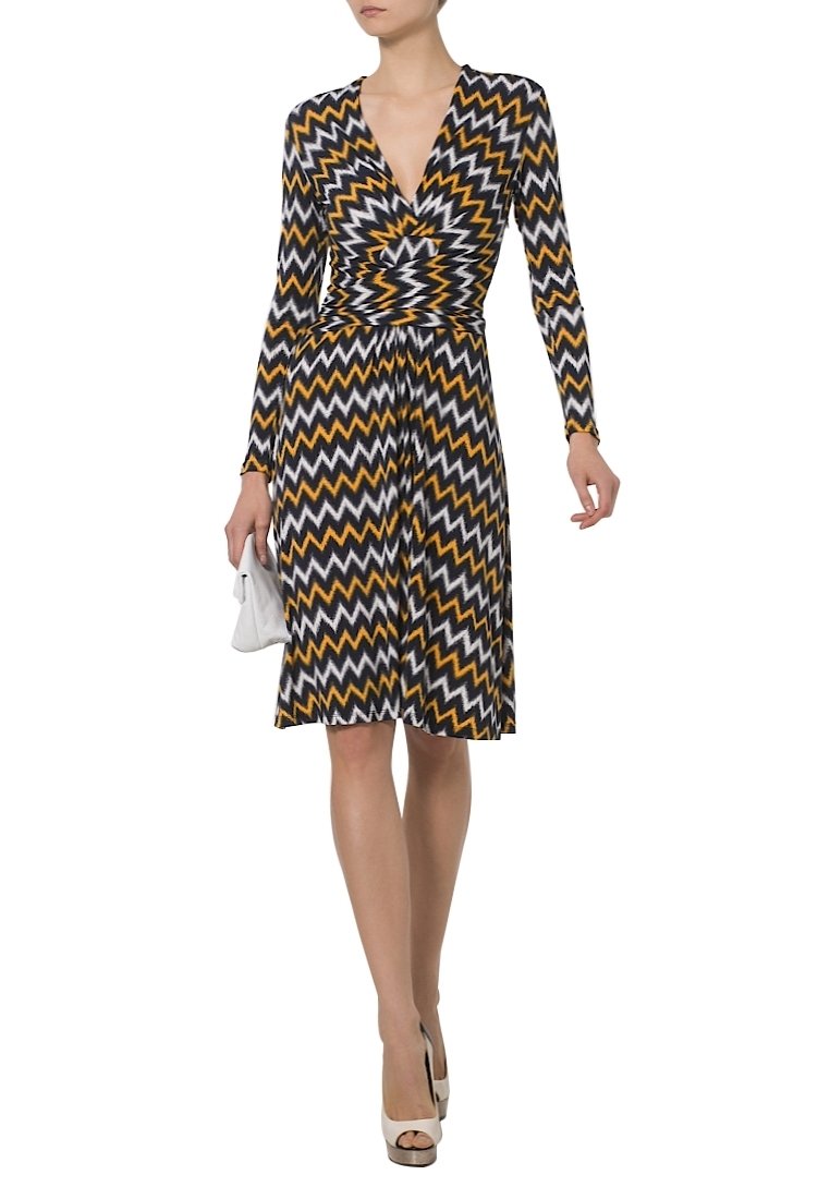 Vestido de manga larga con un patrón de espiga en negro, amarillo y blanco. Diseño cruzado con una cintura ajustada y falda acampanada.