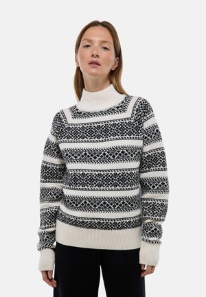 Pull en maille noir et blanc, avec des motifs géométriques, un col haut, des poignets côtelés et un ourlet, fabriqué en tissu doux avec une finition texturée.