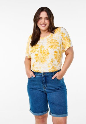 Floral t-shirt with yellow and white pattern, paired with denim shorts featuring a rolled hem and five-pocket design.