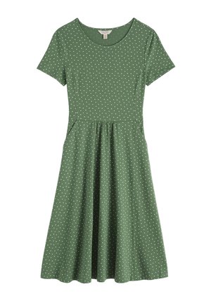 Roheline lühikeste varrukatega põlveni ulatuv kleit, millel on valged täpid ja liibuv talje, ümara kaeluse ja lehviva seelikuga.