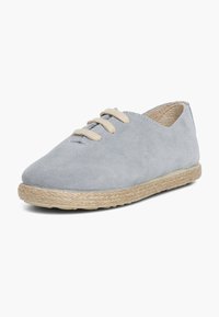 Chaussure à lacets en daim gris avec un bout arrondi et une couture surélevée, comprenant une semelle en fibres naturelles et des accents de lacets beiges.