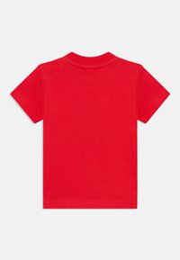 Camiseta de algodón roja con mangas cortas, cuello redondo y textura suave. Sin patrones ni gráficos, diseñada para el uso casual.