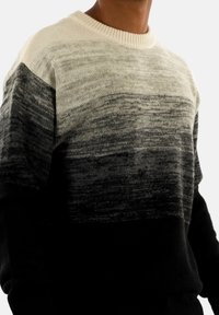 Suéter de punto con un diseño degradado que va del crema al negro, con una textura suave y un cuello y puños acanalados.