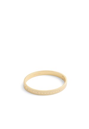 Gold-colored bangle bracelet features a smooth surface with cut-out patterns and embedded rhinestones, creating a contemporary design.