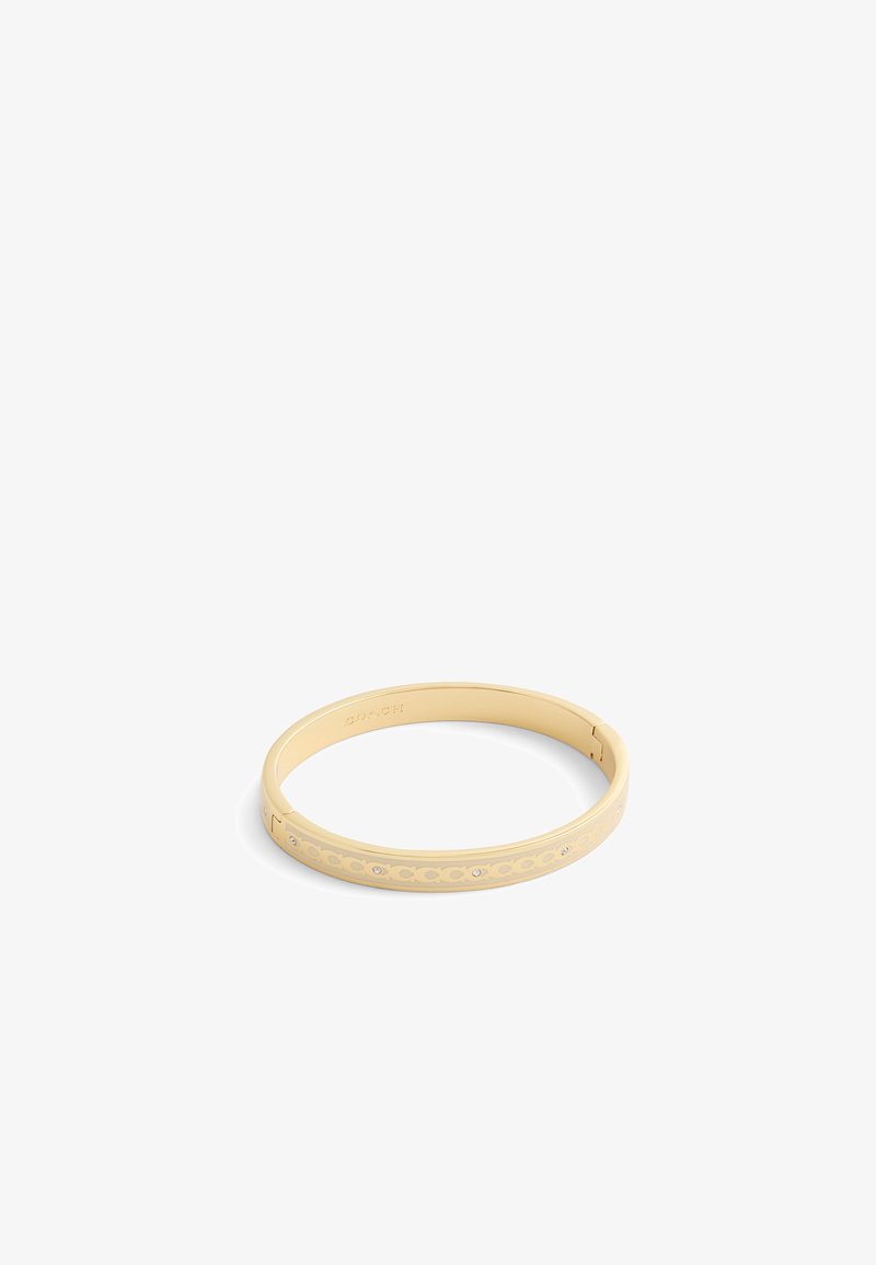 Gold-colored bangle bracelet features a smooth surface with cut-out patterns and embedded rhinestones, creating a contemporary design.
