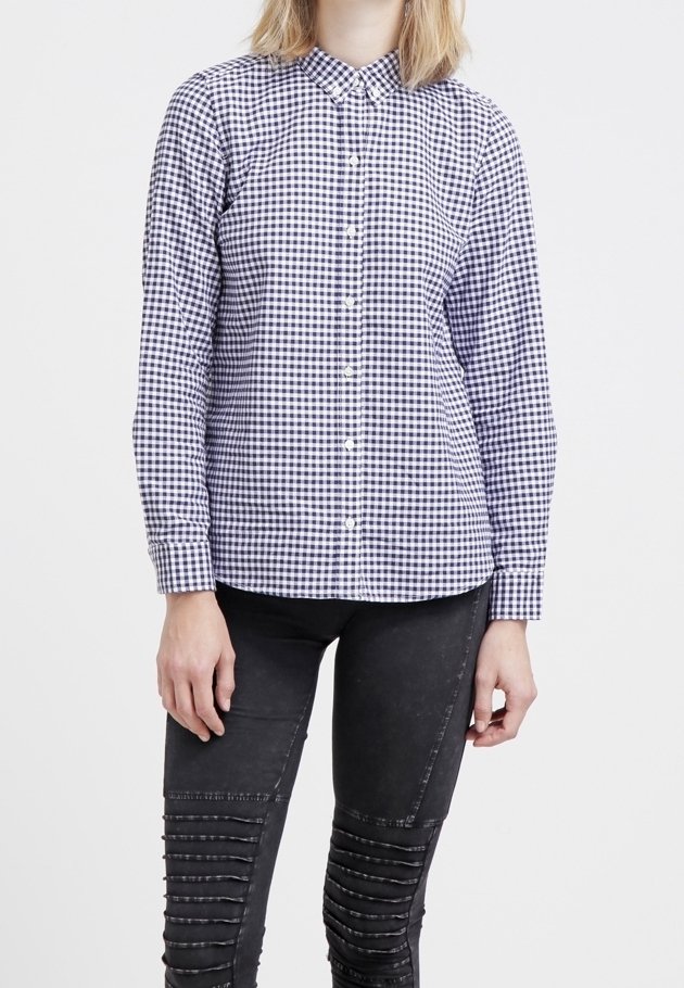 Camicia button-up in una fantasia gingham blu navy e bianca, con colletto, maniche lunghe e un taglio aderente. Abbinata a jeans skinny neri con texture.