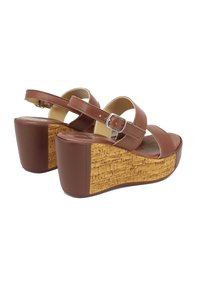 Sandali a zeppa in pelle marrone con cinturino regolabile e tacco dalla texture di sughero. Design open toe con interno liscio.