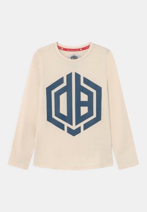 Beige langærmet skjorte med stort mørkeblåt geometrisk logo centreret foran, med rund halsudskæring og rød inderkravekant.