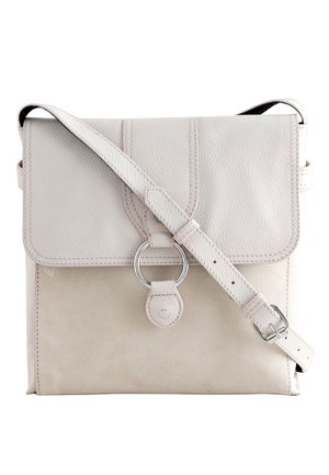Sac bandoulière en cuir et daim beige clair avec rabat, bandoulière réglable et détail d’anneau circulaire argenté sur le devant.