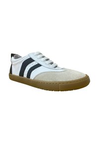 Zapatilla blanca y gris con punta de ante, tres rayas negras en el lateral y una suela de goma; cuenta con cordones redondos y un diseño de caña baja.