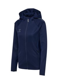 Marinblå zip-up hoodie i mjukt tyg, med hög krage, två sidofickor och reflekterande detaljer på axlarna.
