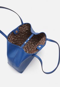 Niebieska skórzana torba tote z otwartym topem. Wnętrze z wyściółką w panterkę, zapięciem na zatrzask i dwoma uchwytami. Teksturowany zewnętrzny.