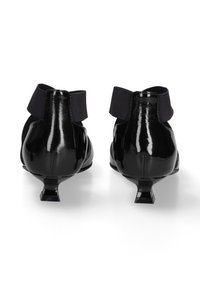 Stivaletti in vernice nera con fascia elastica nera in satin, tacco quadrato piccolo e finitura liscia e lucida. La vista posteriore mostra un design elegante.