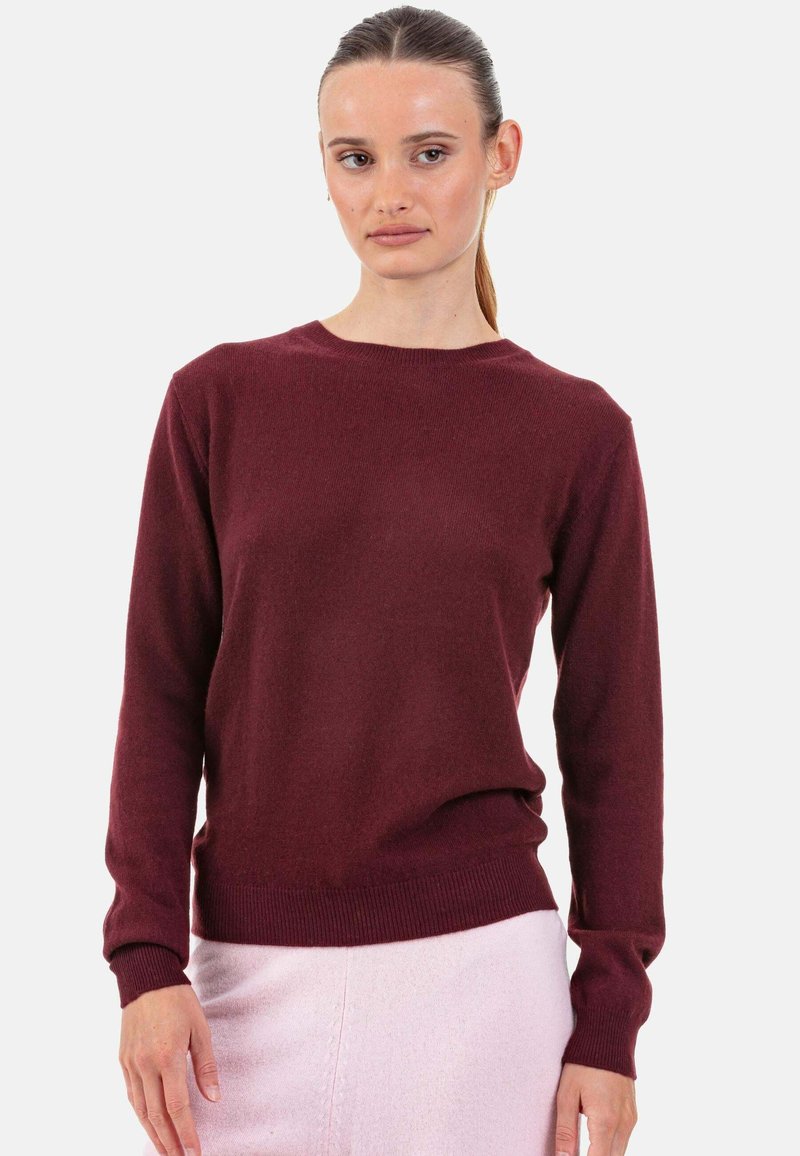 Pull tricot bordeaux à manches longues, col rond, poignets et ourlet côtelés, fabriqué en tissu doux, présenté sur un fond blanc uni.