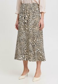 Jupe midi imprimée léopard beige et noire, avec une texture lisse, une taille élastique et un design évasé pour faciliter les mouvements.