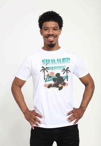 Weißes Baumwoll-T-Shirt mit dem Text "SUMMER VIBES" und einem Grafikmotiv eines Charakters am Strand mit Palmen und einem Sonnenuntergang.