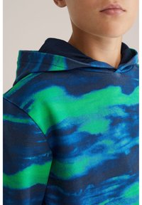 Felpa con cappuccio caratterizzata da un motivo tie-dye blu e verde, in cotone, con un design semplice e un cordino al collo.