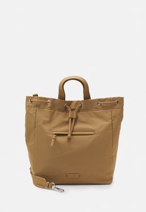 Brown fabric tote bag with top handles, drawstring closure, and an exterior zip pocket; adjustable shoulder strap; smooth texture.