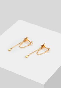 Pendientes en tono dorado con un diseño de cadena colgante que presenta acentos redondos y un pequeño detalle de cristal, exhibiendo una estética delicada y minimalista.