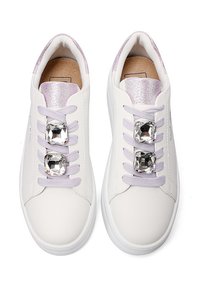 Sneakers bianchi con una finitura in pelle liscia, dettagli in glitter viola sulla linguetta e lacci decorati con strass. Punta tonda e suole piatte.
