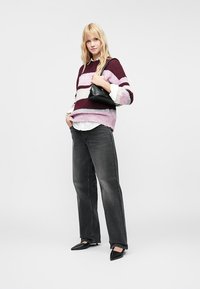 Pulôver de malha em riscas bordeaux, rosa e cinza; combinado com uma camisa branca, jeans cinza escuro e sapatos pretos de bico fino. Pequena bolsa preta.