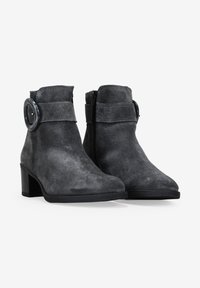 Botines de ante grises con puntera redondeada, tacón cilíndrico y una hebilla decorativa en la correa. Cierre lateral con cremallera para ponérselos fácilmente.