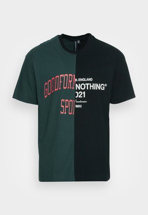 Two-tone T-shirt with green and black panels. Features red text "GOODFORM" and "SPORT" on green; white text "NOTHING 2021" on black. Cotton material.