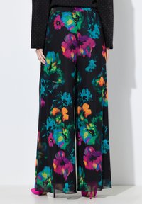 Široké kalhoty z černé látky s živým květinovým vzorem v růžové, zelené a oranžové barvě. Hladká textura s elastickým pasem.