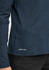 Navy Langarmhemd aus feuchtigkeitsableitendem Stoff, mit einem „Quick Dry“-Etikett nahe dem Saum und flach genähten Nähten für zusätzlichen Komfort.