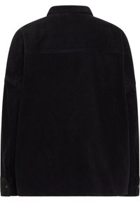 Chaqueta camisa de pana negra con cuello puntiagudo, mangas largas y puños con botones. Tejido texturizado con detalle de canalé horizontal.