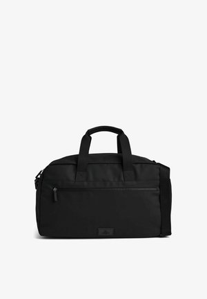 Sac polochon noir avec deux poignées, une poche avant zippée et une bandoulière réglable sur fond blanc.
