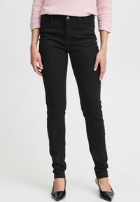 Zwarte skinny jeans met een hoge taille, gemaakt van stretchy denim. Beschikt over vijf zakken, een sluiting met een knoop aan de voorkant en heeft een strakke pasvorm.