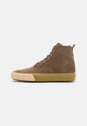 Brauner Wildleder-High-Top-Sneaker mit beige-gummierter Sohle und Zehenschutzkappe, Metallösen und Zuglasche an der Ferse.