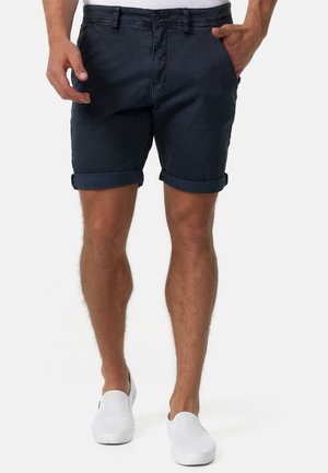 Shorts blu navy con risvolto realizzati in tessuto leggero, caratterizzati da una superficie texturizzata, chiusura frontale con bottoni e tasche laterali.