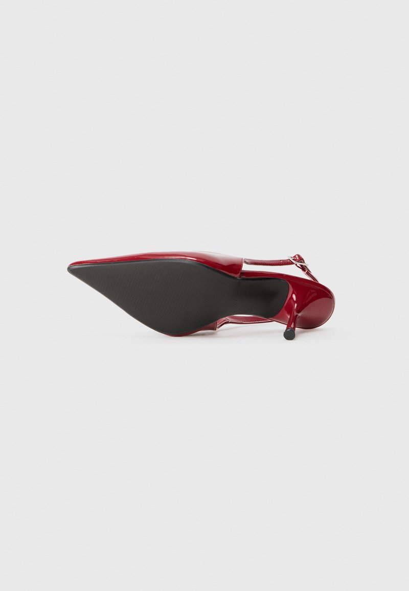 Scarpa con tacco alto in pelle verniciata rossa con punta affusolata, dotata di un tacco sottile e una suola nera testurizzata.