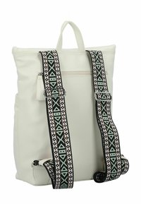 Mochila blanca texturizada con correas decorativas de patrones en tonos negro, teal y marrón. Cuenta con un asa superior y un bolsillo con cremallera.