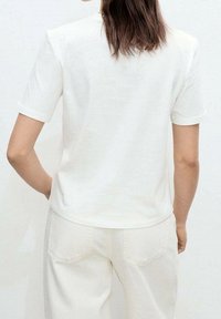 T-shirt en coton blanc à manches courtes, col rond et coupe décontractée, présenté de dos sur un fond neutre.