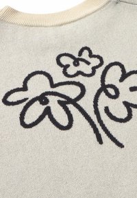 Light beige knit sweater featuring dark floral embroidery with three stylized flowers. Ribbed neckline. Soft texture.