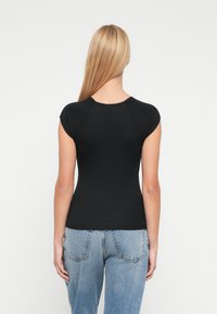 Μαύρο κοντομάνικο μπλουζάκι με εφαρμοστή γραμμή και στρογγυλό λαιμό, φτιαγμένο από απαλό, ελαστικό υλικό.